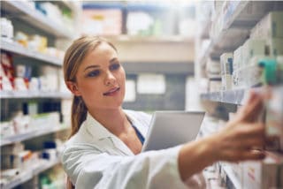 Female pharmacist is searching medicines on shelves